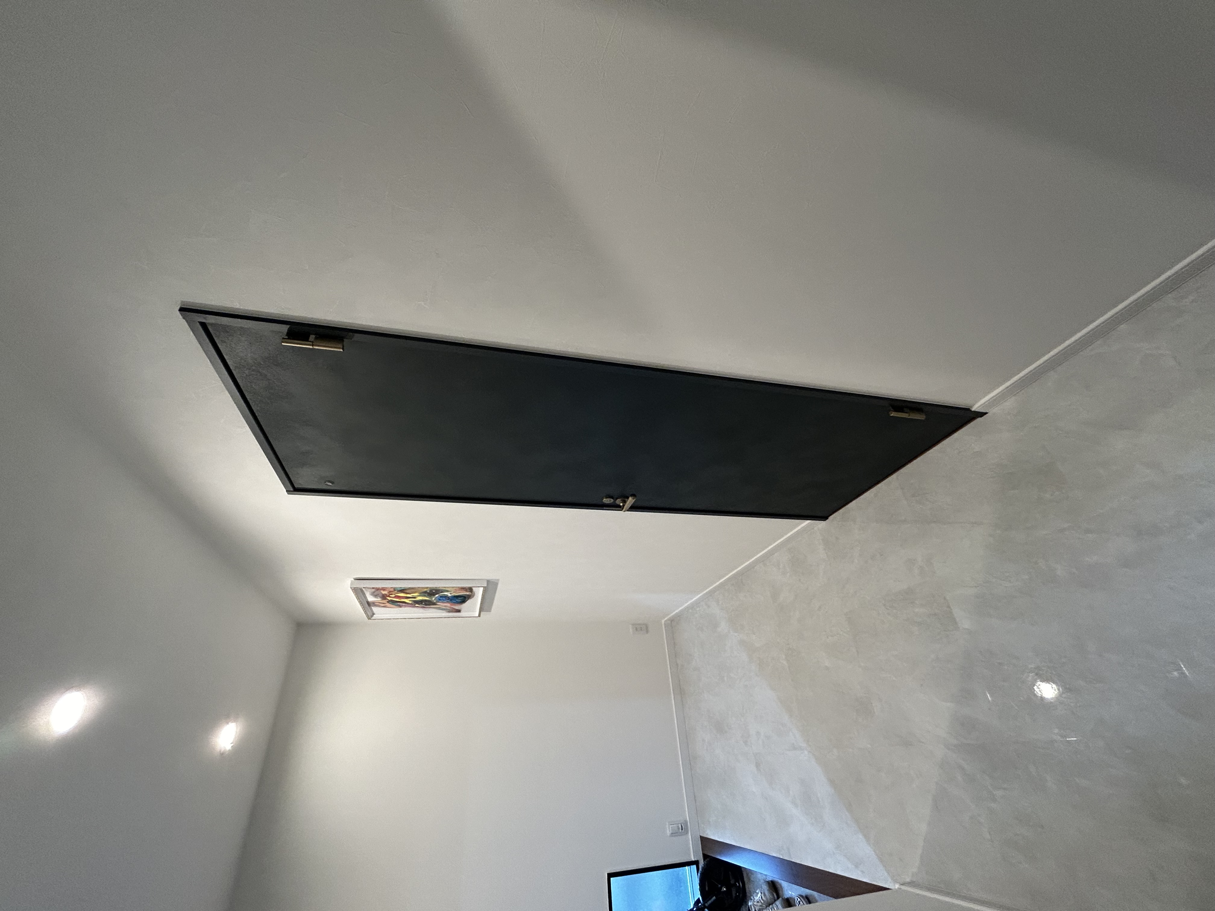 光沢タイルのホールと黒の建具